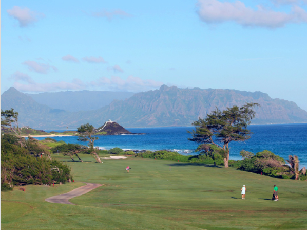 Golfers on a green at Kāneʻohe Klipper with Mōkapu peninsula and the Koʻolau mountains in view