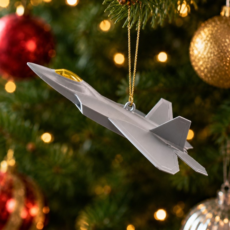 Concept silver F-22 aircraft Christmas ornament hanging on a tree